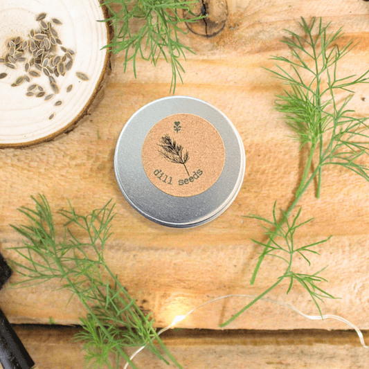 Organic Dill Seeds tin on wooden board with dill sprigs and seed bowl