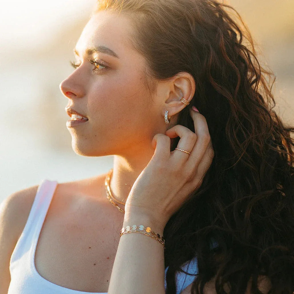 Gold-filled coin bracelet with linked round discs worn on a model's wrist
