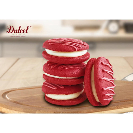 Stack of red velvet cookies with white filling and piped frosting