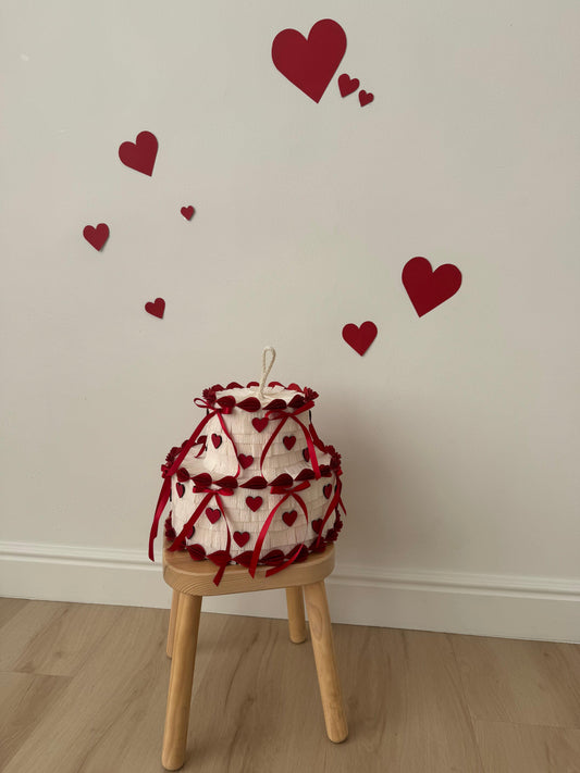 Valentine’s Day cake with red heart decorations and hanging ribbon edges