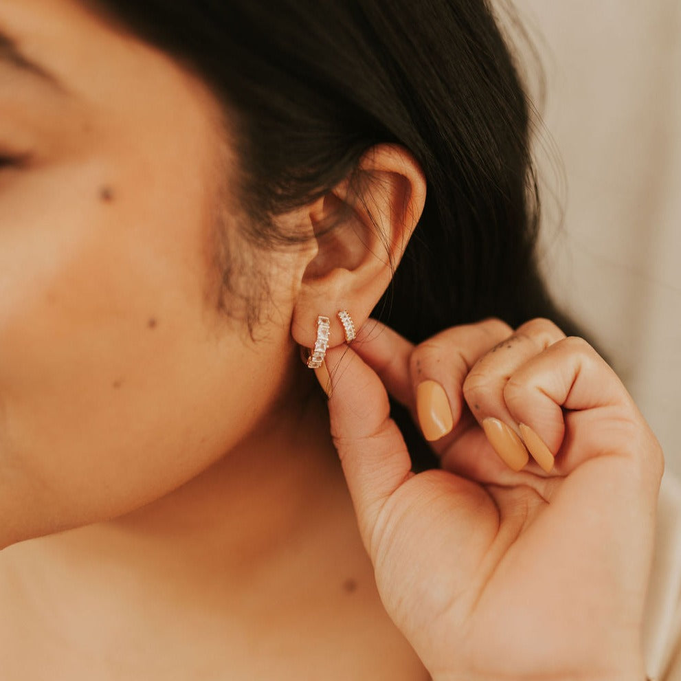 Gold-filled diamond hoops being adjusted on the ear