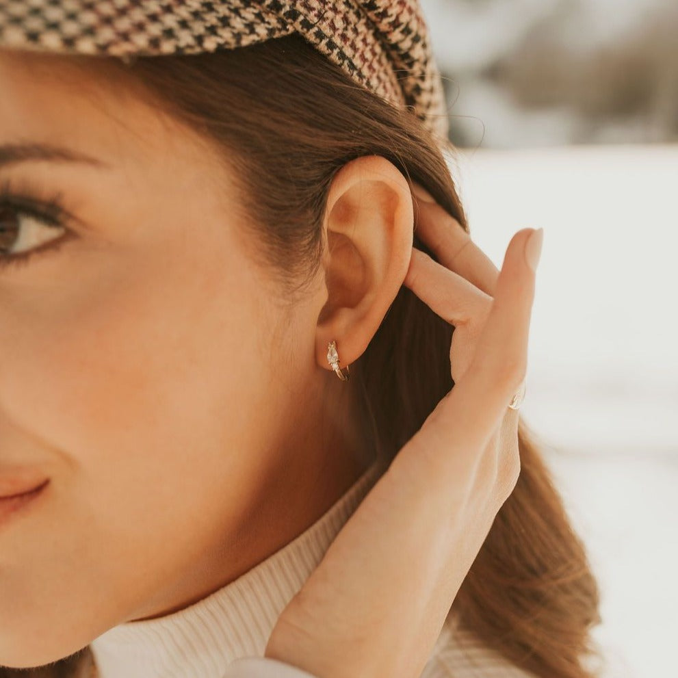 Natalie gold-tone hoop with clear stone accents, worn on an ear