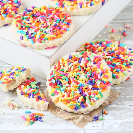 Sprinkle-coated sugar cookies in a gift box, close-up view
