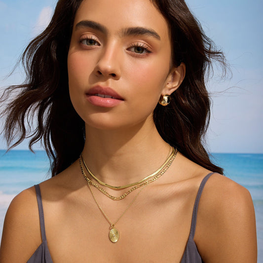 Gold sphere hoop earrings on ear, hinged clasp visible