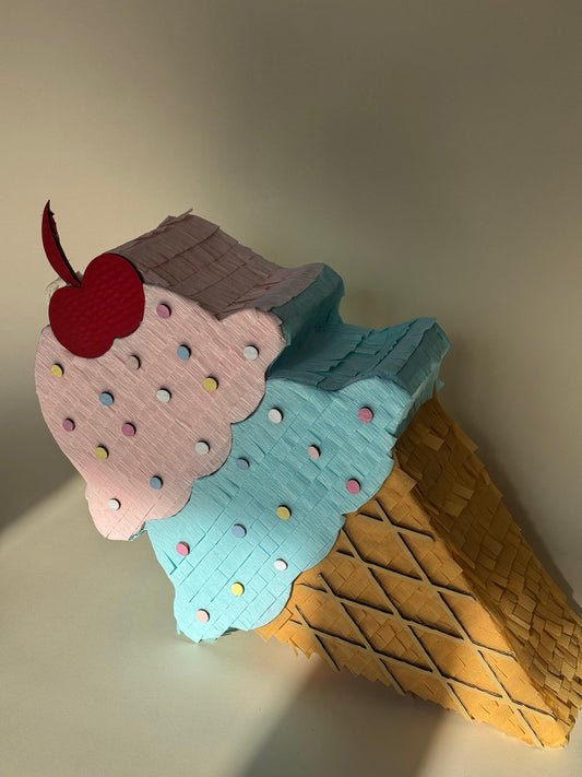 Light blue ice cream cone piñata with multicolor sprinkles, red cherry, brown waffle cone