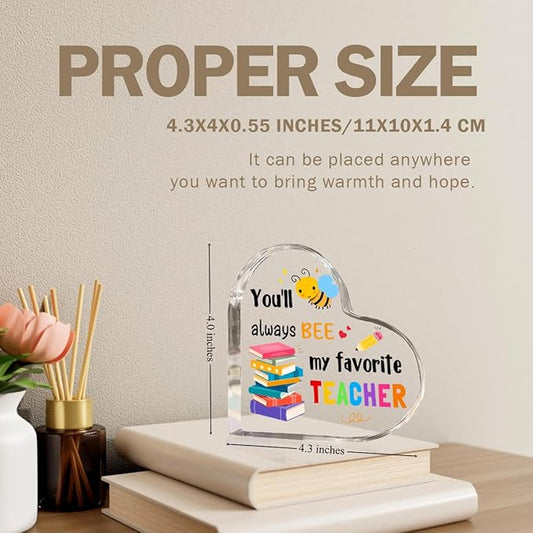 Clear acrylic heart teacher gift with bee and 'favorite TEACHER' message on books.