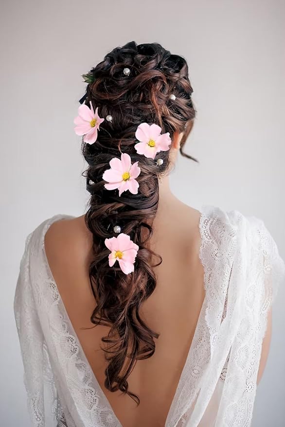 Light pink faux daisy-style blossoms used as hair accents on dark hair