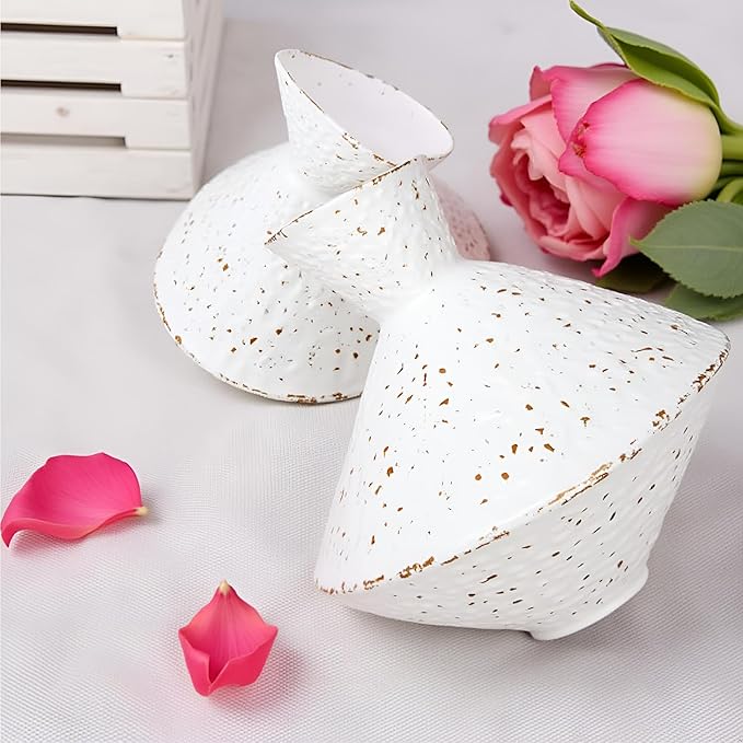 White hammered cast iron vase with angled neck, speckled finish, with flower blooms nearby