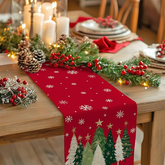 Red Christmas table runner with scattered snowflakes and pine tree border design