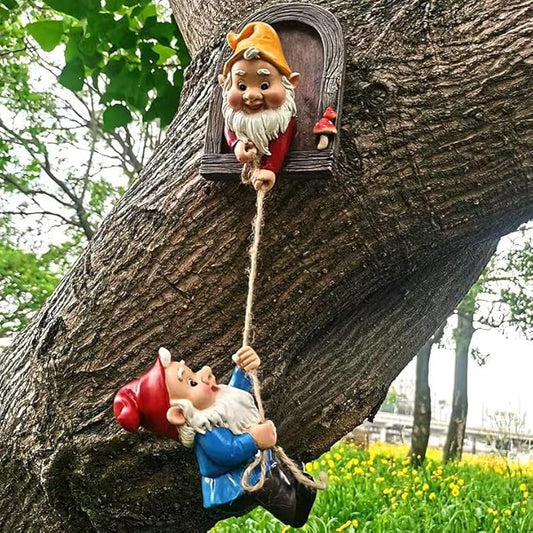 Outdoor tree gnome decor with orange-capped face in arched doorway and hanging blue outfit