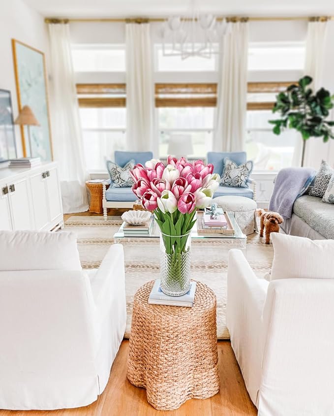 Artificial pink tulip stems in a clear vase on a woven table center