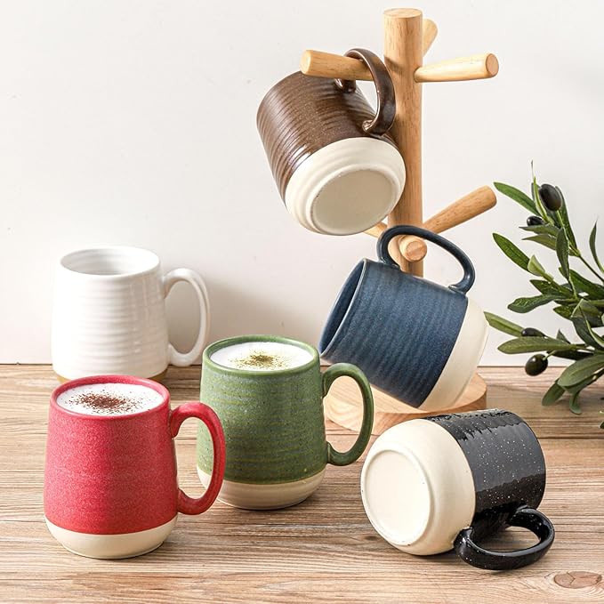 Ceramic coffee mugs in white, red, green, and blue arranged around a wooden rack.