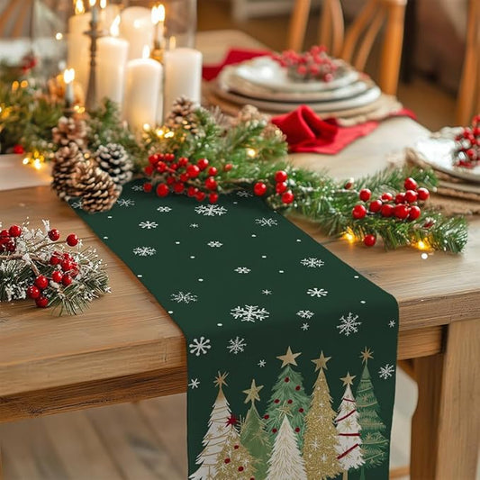 Green table runner with scattered snowflakes and Christmas tree artwork along one edge