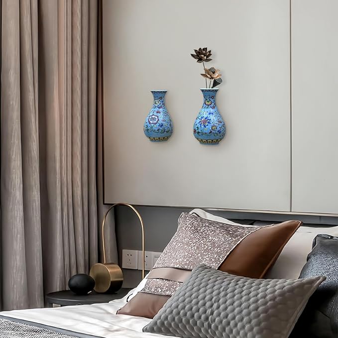 Two blue chinoiserie porcelain wall vases mounted on a light gray wall