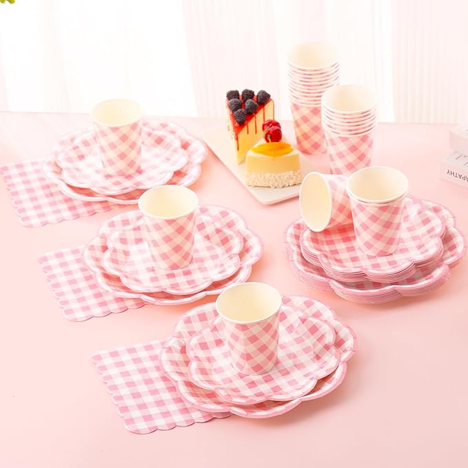 Pink gingham picnic tableware set with cups, plates, and utensils on table