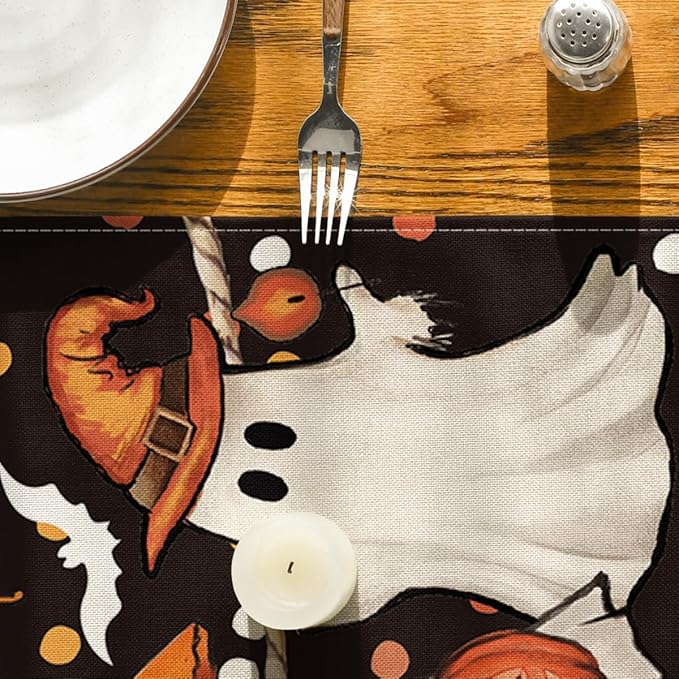Close-up of Halloween table runner fabric with orange pumpkin shapes and ghost artwork