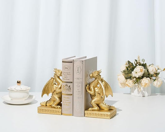 Pair of gold dragon bookends holding upright books on shelf