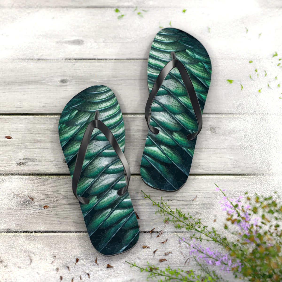 Two green scale-pattern flip-flops with black straps, one sandal slightly turned