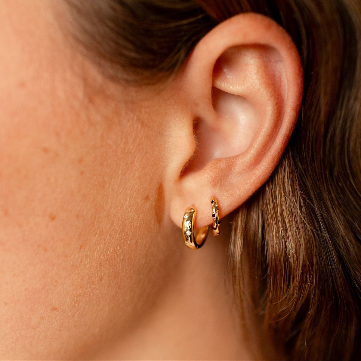 Black-dotted gold vermeil hoop worn beside a plain gold hoop