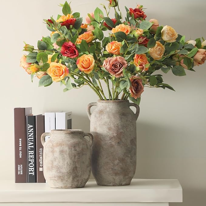 Rustic gray ceramic vase with side handles holding orange and pink rose bouquet