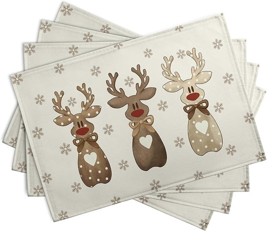 Set of four beige reindeer placemats with snowflake pattern, folded and stacked