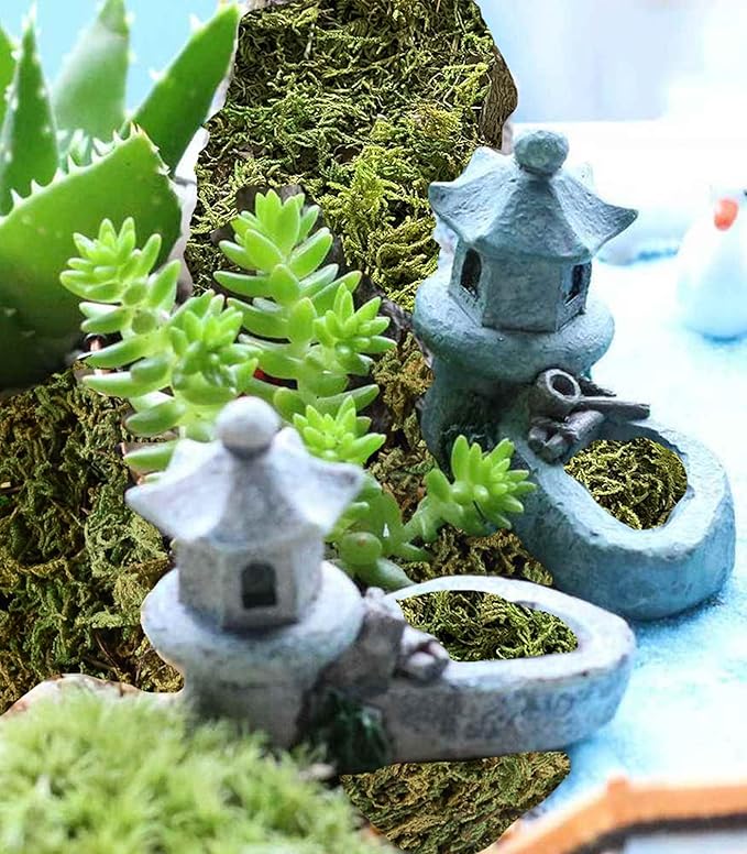 Light green faux moss base with succulent decorations and small fairy garden figurines
