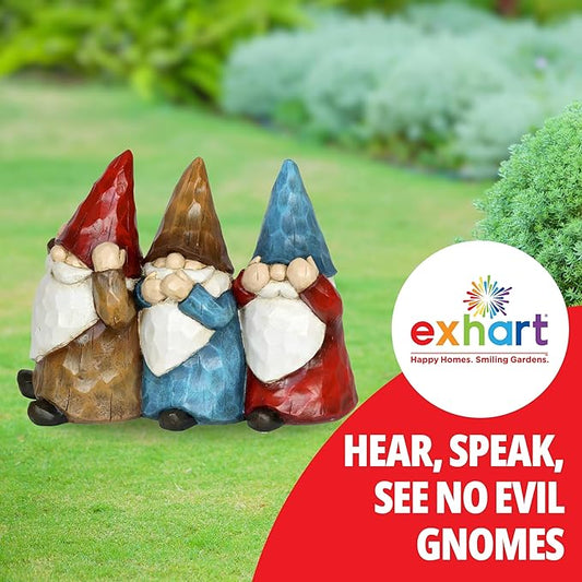 Three painted garden gnome statues standing together, red blue and brown hats with white beards