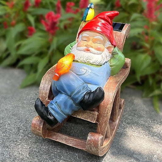Solar garden gnome statue on wooden rocking chair, red hat and blue overalls