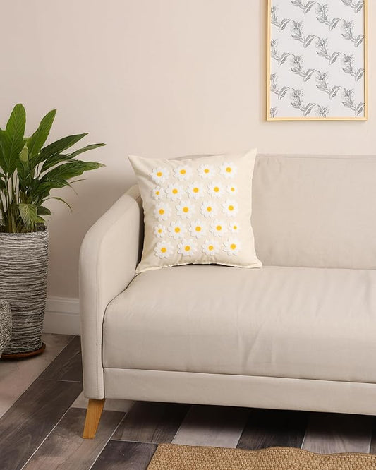 Daisy throw pillow cover on sofa, white fabric with yellow flower centers and textured stitching
