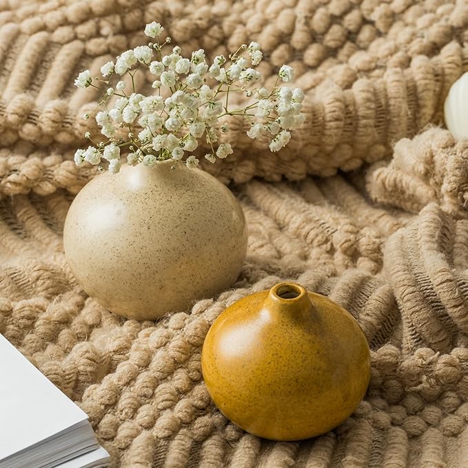 Mini ceramic bud vases on textured fabric: speckled cream and glossy gold.