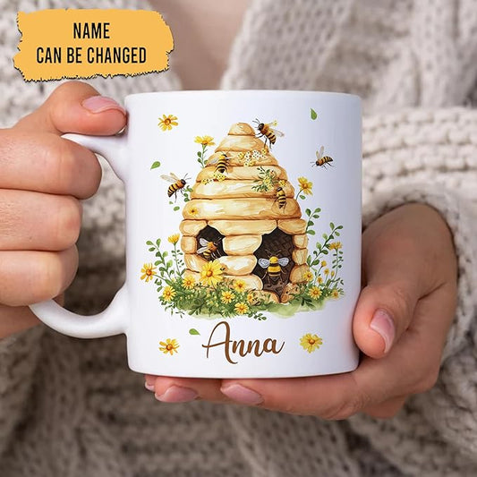 White ceramic bee mug with stacked honeycomb beehive, small flowers, and Anna