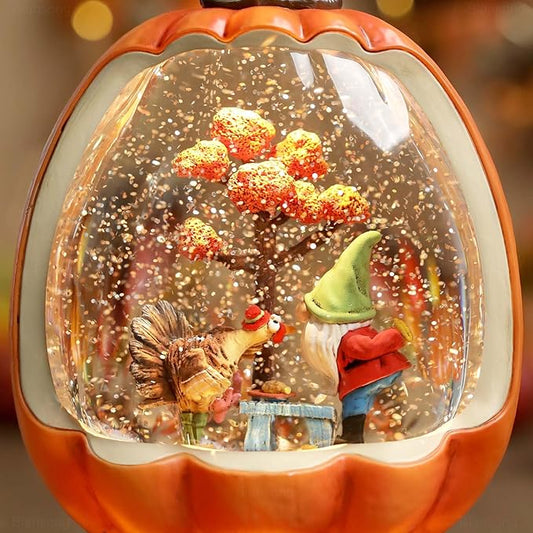 Orange pumpkin snow globe close-up with glitter filling the dome around the fall figures
