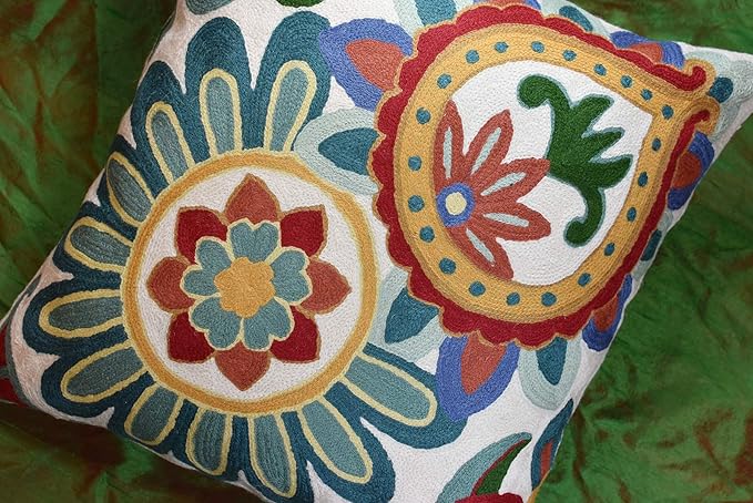 Embroidered floral pillow cover with two circular designs in teal, blue, red, and green on cream