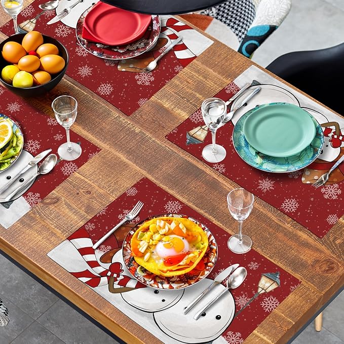 Red snowman snowflake placemat on a wooden dining table with dinnerware and glasses