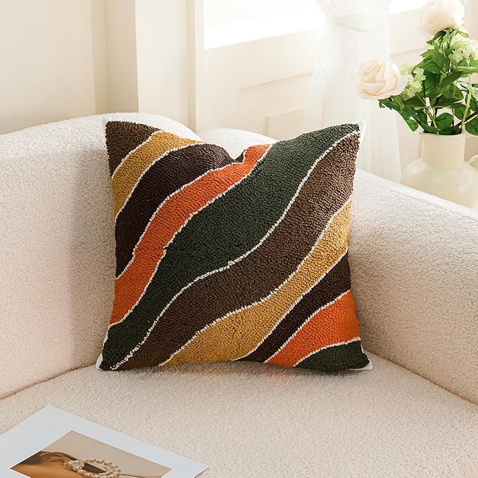 Tufted throw pillow cover with curved striped pattern in dark green, brown, orange, and tan