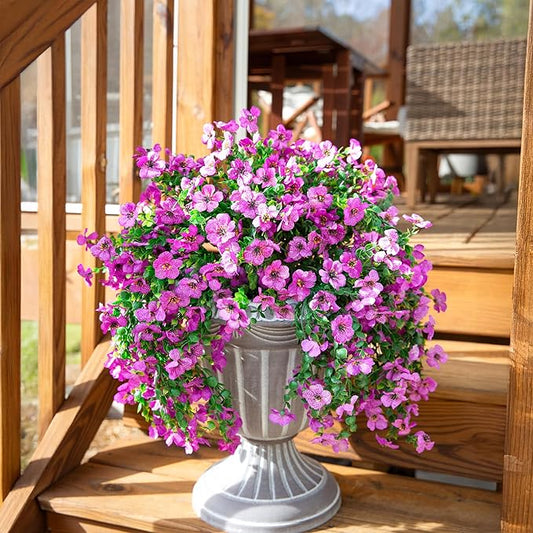 Purple faux hanging flower bundle with trailing vines over a gray pedestal pot