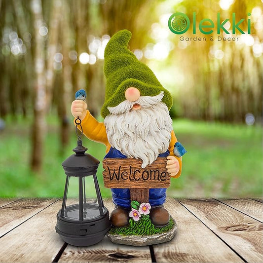 Green-hat garden gnome figurine holding a solar lantern and “Welcome” sign on a wooden patio