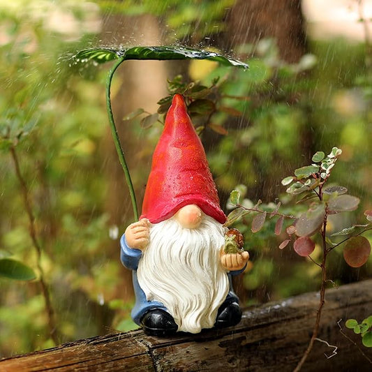 Garden gnome statue with leaf umbrella in rain, red hat and white beard