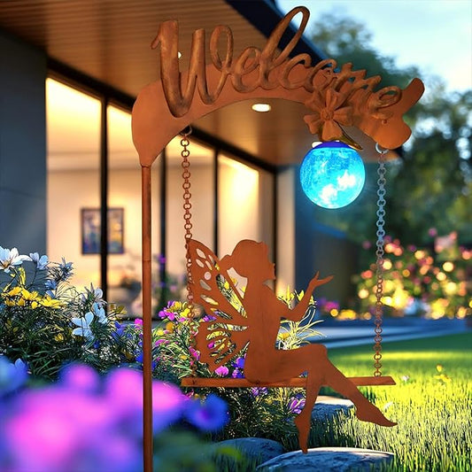 Solar fairy garden light with rust stake, fairy cutout, and glowing blue sphere in yard