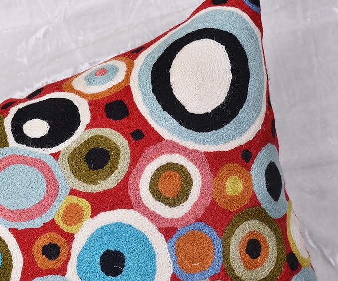 Side view of red circular-pattern pillow cover with overlapping multicolor rings