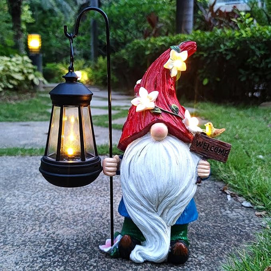 Solar garden gnome statue holding a black lantern with warm glowing light, red flower hat