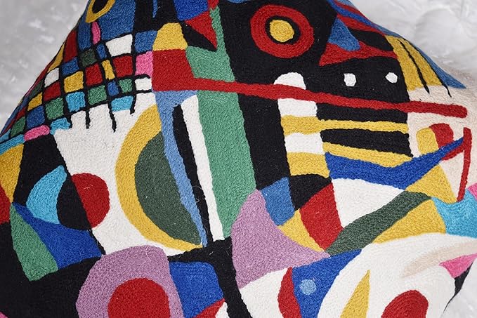 Black abstract embroidered decorative pillow cover with colorful geometry and circular accents, wide view.