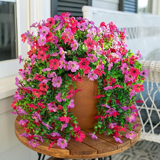 Purple and hot pink faux hanging flowers with green trailing greenery on round pot