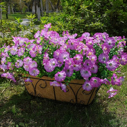 Purple faux morning glory bundles with green leaves, arranged in a garden planter