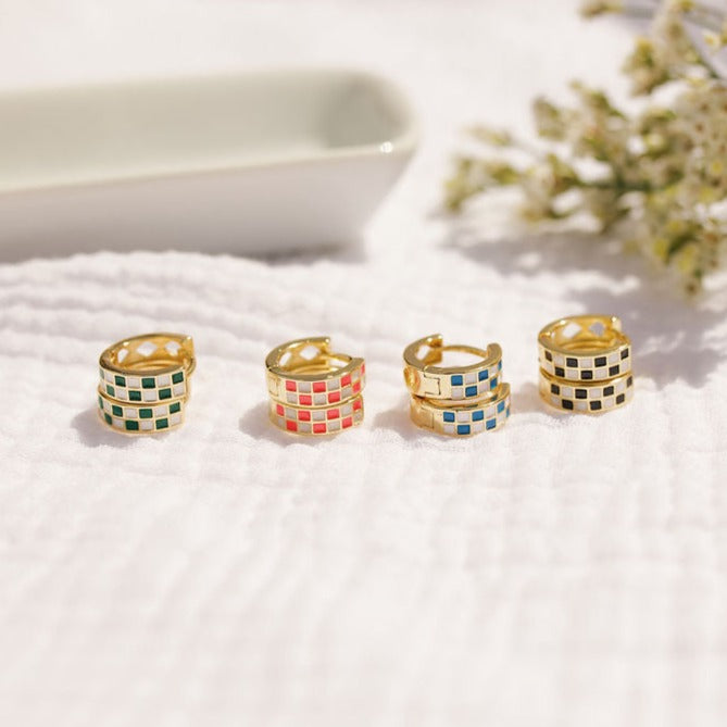 Four pairs of gold checkerboard hoops in green, pink, blue, and black