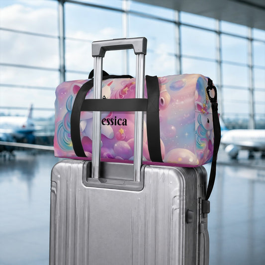 Pastel unicorn duffel bag with black straps secured to rolling luggage handle