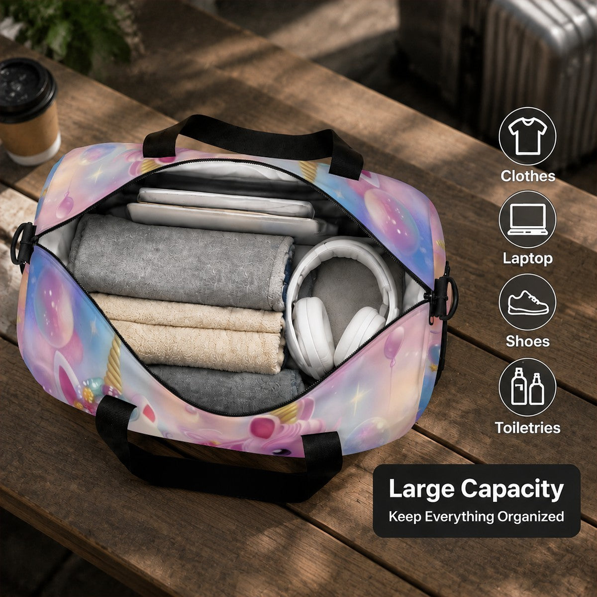 Unzipped pastel unicorn duffel bag with black handles, showing interior storage