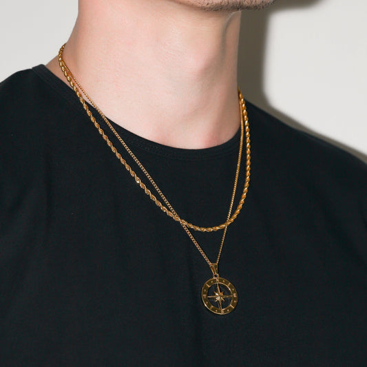 Gold compass pendant necklace set with two-layer chains on dark shirt