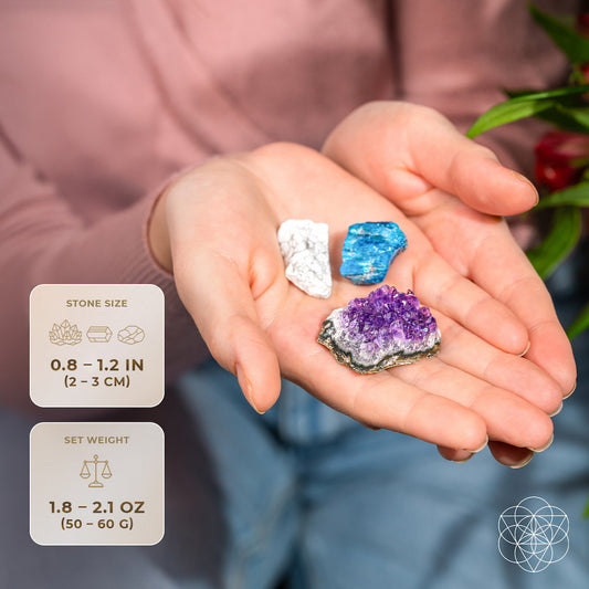 Trio of small raw crystals in an open palm: white, blue, and purple