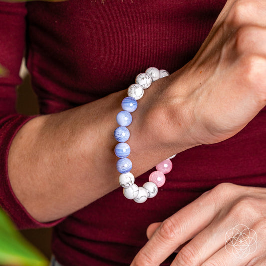 Trio beaded gemstone bracelet worn on wrist with pink, white, and light blue beads